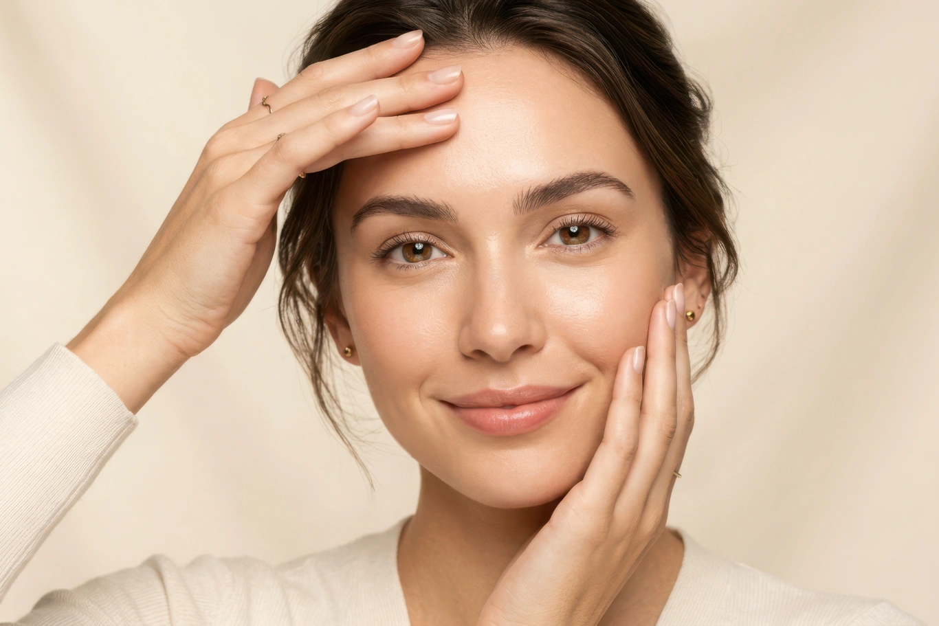 Smiling woman touching her forehead and cheek showcasing smooth wrinkle-free skin following Botox treatment for forehead lines
